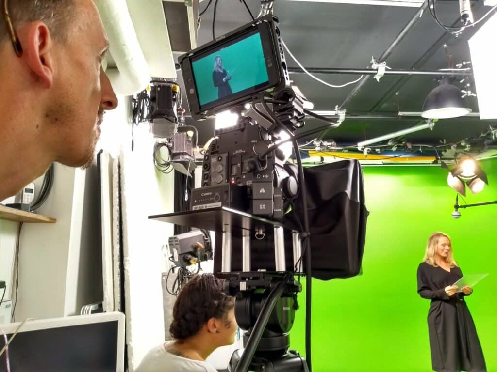 Équipe de tournage devant la caméra et le moniteur pendant le faux JT Volvo France sur fond vert