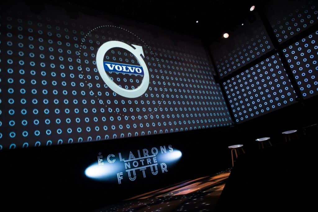 Scène de la convention Volvo Car France : écrans projetant le logo Volvo et le titre « Éclairons notre futur »