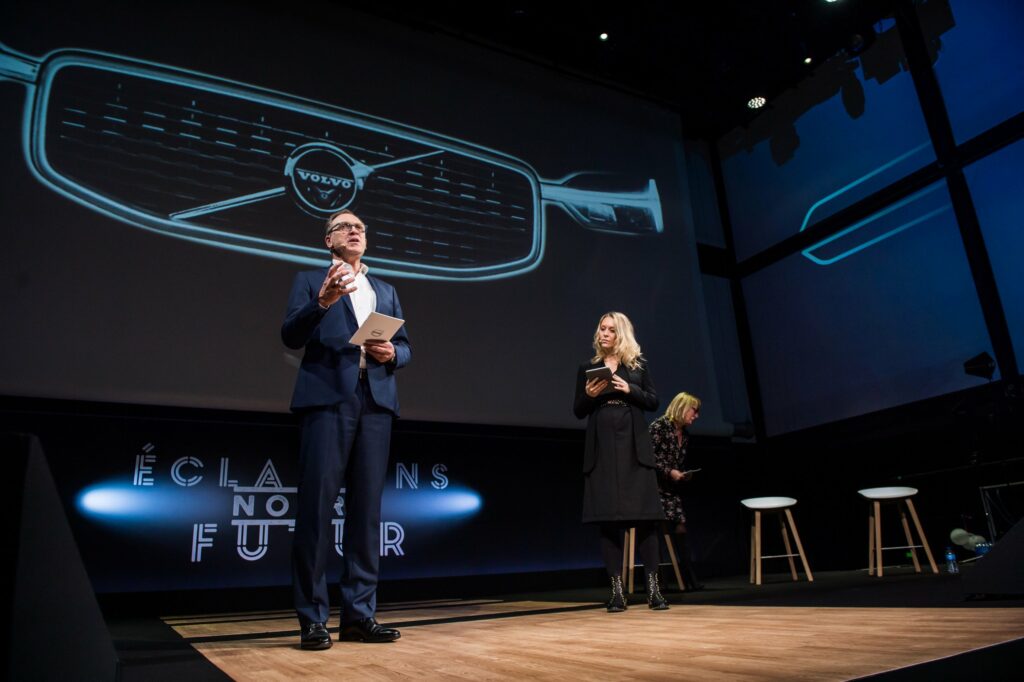 Intervenants sur la scène de la convention Volvo Car France devant un écran projetant une calandre Volvo