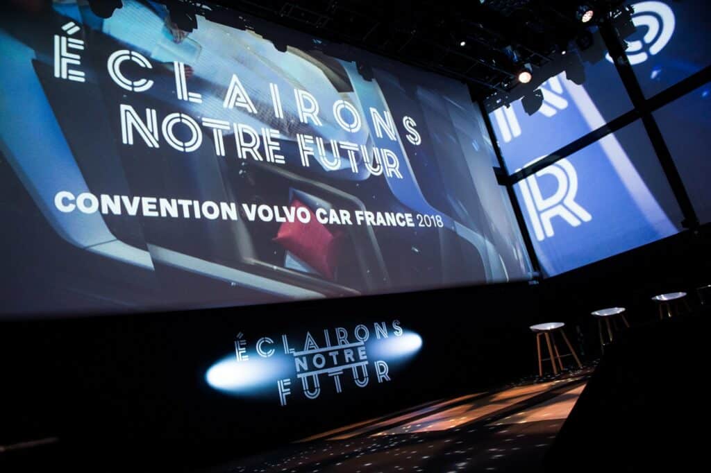 Écran « Éclairons notre futur — Convention Volvo Car France 2018 » projeté sur le mur d’écrans de la scène